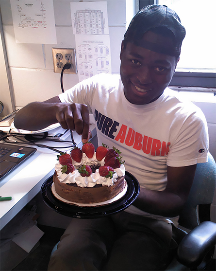 René Fuanta in graduate school at Auburn University, about to sample some tasty strawberries at his study bench.