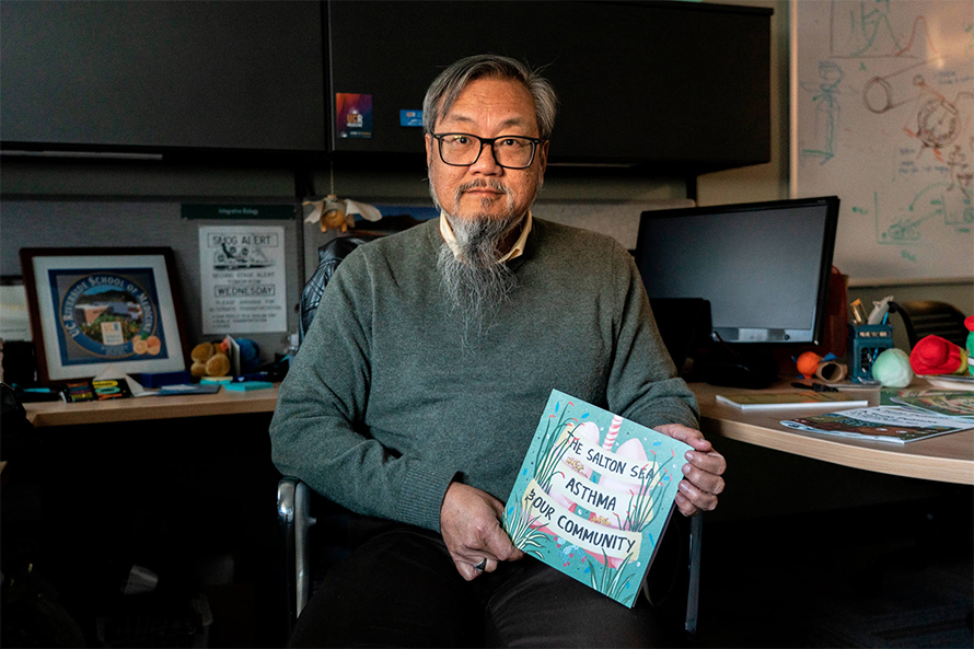 Biomedical researcher David Lo holds an educational comic book about asthma and the potential role of Salton Sea dust, which he edited and published. After studying the region for nearly a decade, Lo recommends that anyone visiting the lake wear an N95 mask.