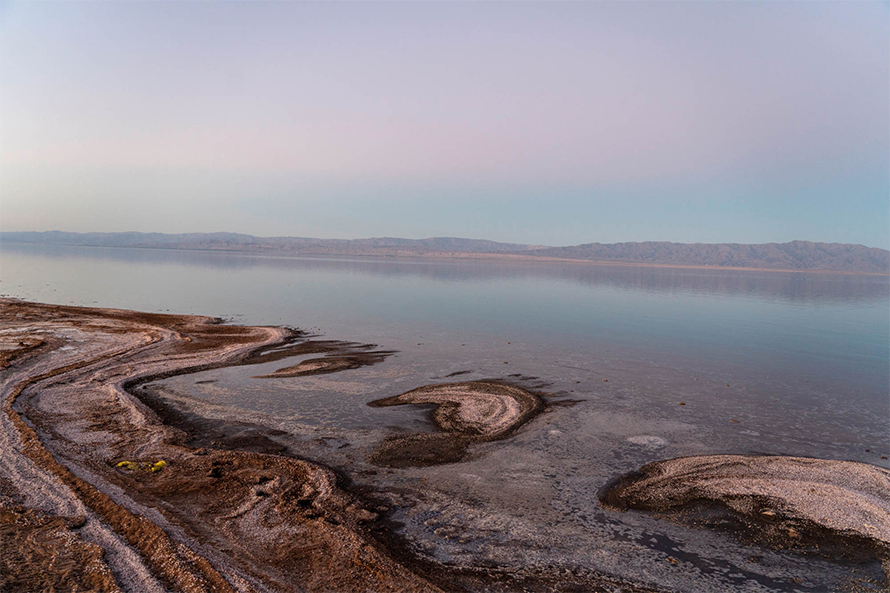 The Salton Sea captured from the beach near Salton City, California. As the waterline recedes, large areas of lakebed are exposed, leaving a fine dust that is blown by the wind into nearby communities. Scientists now suspect that a bacterial toxin in that dust, known as LPS, is triggering an asthma-like lung disease in residents of the region.