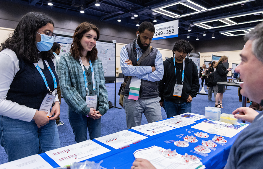 ASBMB Science Outreach and Communication Committee member Mike Wolyniak, at left, talks to local high school students at the Community Day “Whodunit?” forensic science station.