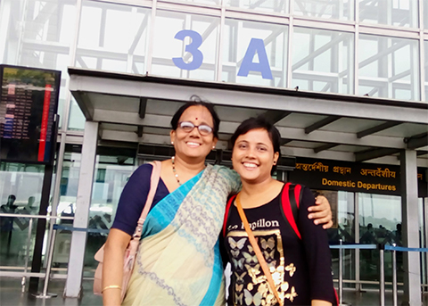 Before leaving India for the U.S. in July 2016, Ishita Ghosh stands with her mother, Kakoli, outside the airport entrance in India.