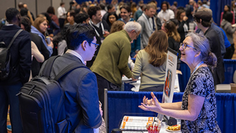An exhibitor talking with a conference attendee