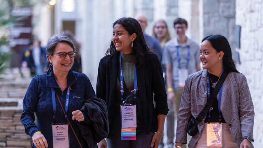 Three meeting attendees walking and smiling