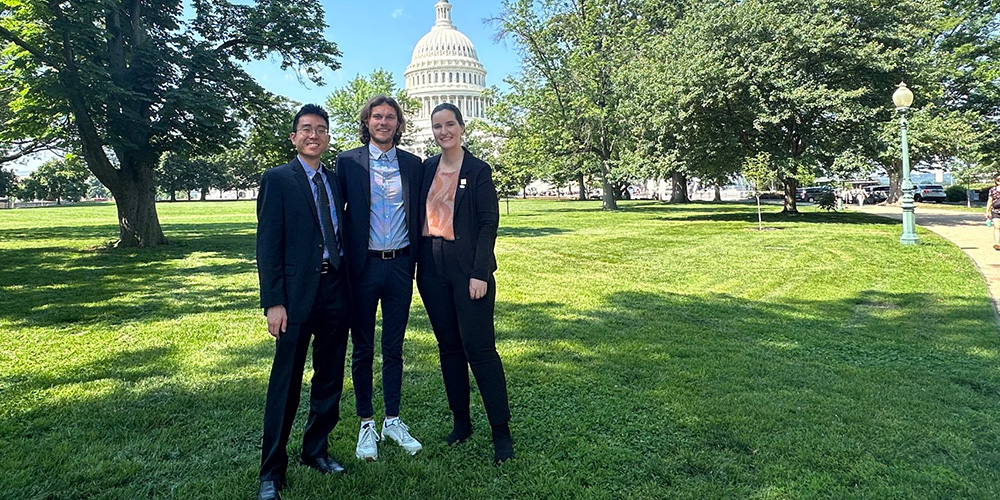 Three ATP delegates pose in front of the U.S. Capitol.